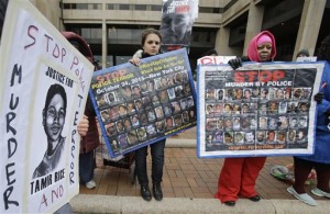 People protest outside the Cuyahoga County Justice Center, Tuesday, Dec. 29, 2015, in Cleveland. People marched peacefully in front of the Justice Center in downtown Cleveland to protest a grand jury's decision not to indict two white Cleveland police officers in the fatal shooting of Tamir Rice, a black 12-year-old boy who was playing with a pellet gun. (AP Photo/Tony Dejak)