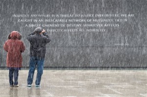 Visitors at the Martin Luther King, Jr. Memorial in Washington stop to photograph the quotes etched into the memorial's back wall while it snows in the Nation's Capital, Sunday, Jan. 17, 2016. The civil rights leader's birthday is celebrated as a federal holiday Monday. (AP Photo/J. David Ake)
