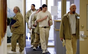 In this photo taken Thursday, Jan. 28, 2016, inmates carry books as they head to classes at the Monroe Correctional Complex in Monroe, Wash. College education in American prisons is starting to grow again, more than two decades since federal government dollars were prohibited from being used for college programs behind bars. The shift comes as everyone from President Barack Obama to state policymakers are looking for ways to get better results from the $80 billion the U.S. spends annually on incarceration. (AP Photo/Elaine Thompson)